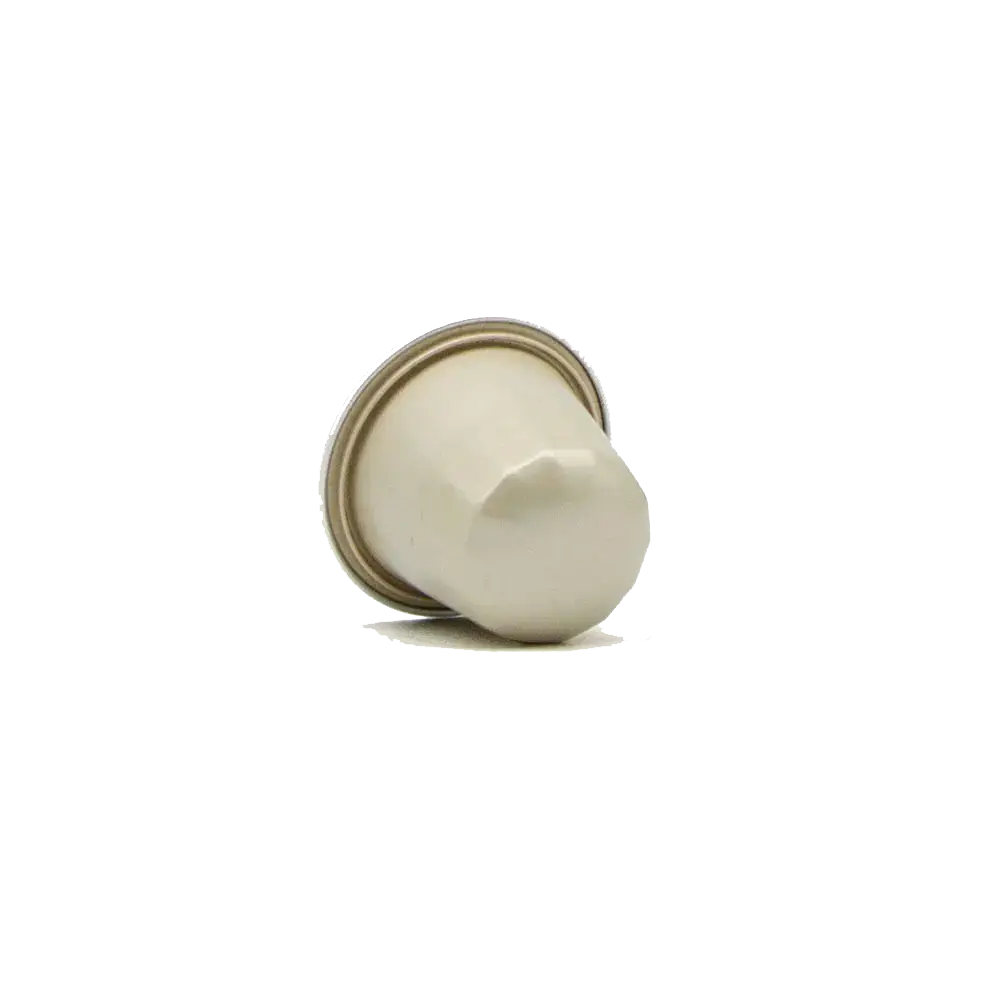 Cream-coloured coffee capsule viewed from the side, showing its dome-shaped top and metallic foil base